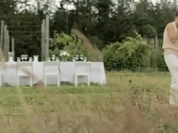 Dinner table and couple drinking wine in field Stock Footage