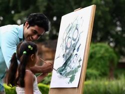 Man teaching painting to his daughter on a easel  Stock Footage