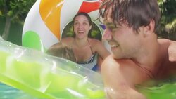 Family playing on inflatable pool rafts Stock Footage