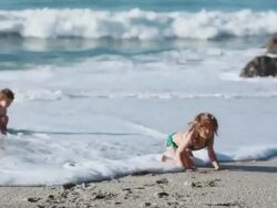 MS TS Girl does cartwheels on beach with boy and ocean / Montezuma, Puntarenas, Costa Rica Stock Footage