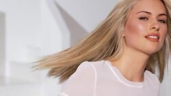 Woman spins creating movement in blonde hair, then looking to camera and smiling Stock Footage