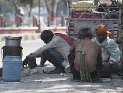 WS Two men and vendor by side of road playing cards and crushing nuts / Patna, Bihar, India Stock Footage