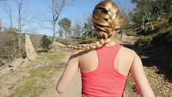 Blond athlete with braided hair jogging in nature Stock Footage