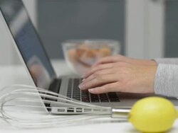 Dolly,L to R Female using laptop computer in kitchen Stock Footage