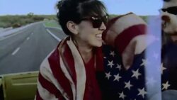 Film footage of friends on road trip draped in American flag in backseat of classic Ford Bronco Stock Footage