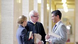Judge and lawyers talking in courthouse hallway Stock Footage