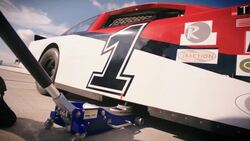 Pit-crewman jacks race-car Stock Footage