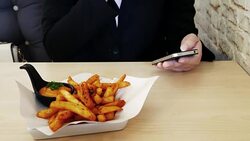 Businesswoman take a break time with french fries and touching smartphone , relaxation concept Stock Footage