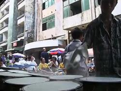 MS Shot of Two men baking bread (pancakes?) on hotplates on street / Yangon, Yangon Division, Myanmar   Stock Footage