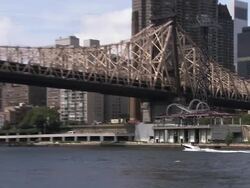Boat passes under Ed Koch Queens Boro Bridge Stock Footage