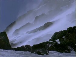 MS Snow being blown up rocky mountain by strong winds, Morocco, Africa Stock Footage