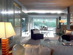 TS across mid-century modern 1955 large living room with fireplace and contemporary furnishings Stock Footage