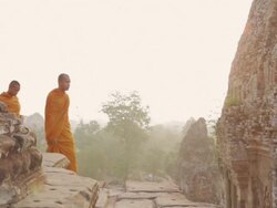 WS, PAN Buddhist monks walk along the top of an ancient temple high above the forest in Angkor Wat at sunrise / Siem Reap, Cambodia Stock Footage