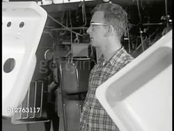 1953: KAISER METAL PRODUCTS: GOING TO WORK: HA PAN Workers walking on sidewalk next to Kaiser Metal Products plant sign. Male inspecting kitchen sinks hanging, moving by on overhead production line. Instructional Video