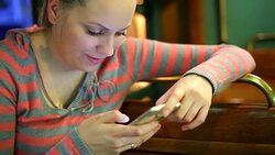 Pretty girl reading sms on smarthphone Stock Footage