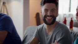 Guys sitting on couch watching funny movie Stock Footage