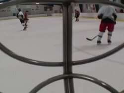 POV hand-held - Seen through a goalie's mask, two ice hockey teams play each other. / North Carolina, USA Stock Footage