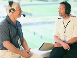Two sports announcers talking about pregame in booth. Stock Footage