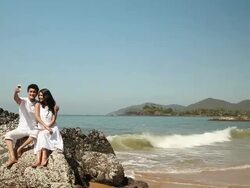 Young couple taking self portrait a mobile phone on the beach   Stock Footage