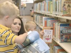 MS mom with two little boys browsing childrens books at public library / Rancho Mirage, California, USA Stock Footage