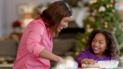 Mother and daughter flatten cookie dough with rolling-pins, choose cookie-cutters (dolly-shot) Stock Footage