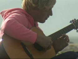 Yong man playing guitar on the beach, Cape Town, South Africa Stock Footage