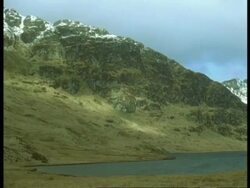 T/L shadows cast by clouds passing over rocky mountain Stock Footage