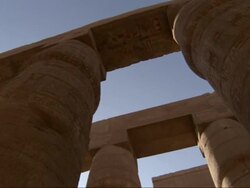 Low Angle, pan-left - Carvings of hieroglyphs cover the columns of ancient adobe buildings / Egypt Stock Footage