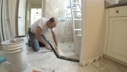 Tile layer installs cement sill for shower door Stock Footage