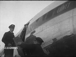 1953: LONDON, ENGLAND: WS British Overseas Airways Corporation (BOAC) Comet jet. MS Production case w/ 'The March Of Time' on side into cargo hold. WS MOT director Dwight Godwin & cameraman John Peters up steps into jet, workers rolling portable stairs. Instructional Video
