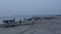 Fisherman return to the banks of the River Jamuna Bangladesh at sunset to unload sell auction and share their catch of small fish before tending to nets and returning home Stock Footage
