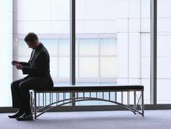  WS Businessman sitting down on bench and working on his smart phone / Seattle, Washington, United States Stock Footage