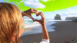 Young woman makes heart shape finger frame on beach Stock Footage