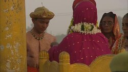 A festival participant adds and removes flower necklaces from around women's necks in India. Stock Footage