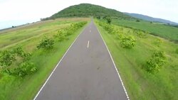 Top view with road on green field and mountain. Stock Footage