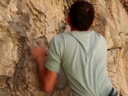 Handheld shot of a rock climber making his way up a cliff. Stock Footage