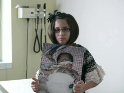 Slow motion of young girl holding up photo of herself when she was a baby in the hospital. Stock Footage