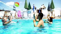 People playing vollebay in swimming pool and having beers. Stock Footage