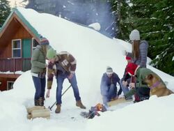 MS group of friends building fire in snow in front of cabin in woods. Stock Footage