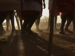 Maasai Ceremony - Warriors dancing, low angle view feet jumping, silhouetted by sun, WITH AUDIO Stock Footage