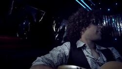 Rockstar strums on acoustic guitar in limo while fans bang on windows and paparazzi snap photos at awards show Stock Footage