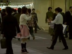 MS Shot of young girl distributing pamphlet to people walking on street at night / Tokyo, Japan Stock Footage