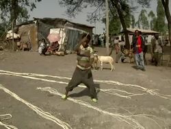 Ethiopan Boy cracks whip at camel market Stock Footage