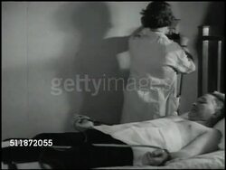 1937: MEDICAL TESTS: Female doctor testing reclined male patient, attaching leads of electrocardiograph to wrist then to wall mount feed, male in lab coat in room w/ machine, monitoring graph, CU Electrocardiogram & spacing measure. Instructional Video
