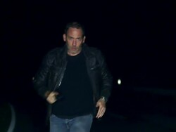 Man with gun running on street Stock Footage