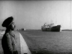 B/W 1956 Egyptian soldier standing on shore of Suez Canal with freighter in background / Egypt / Suez Canal Stock Footage