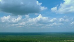 Fluffy clouds drift above a lush, flat landscape in Mississippi. Stock Footage