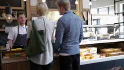 Worker serving customers at deli counter Stock Footage