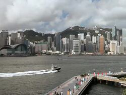View across Hong Kong Harbour from Tsim Sha Tsui towards  Wan Chai, Hong Kong Island, walkway (Avenue of Stars) in foreground. Stock Footage