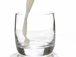 Milk being poured into Glass against white background, slow motion Stock Footage
